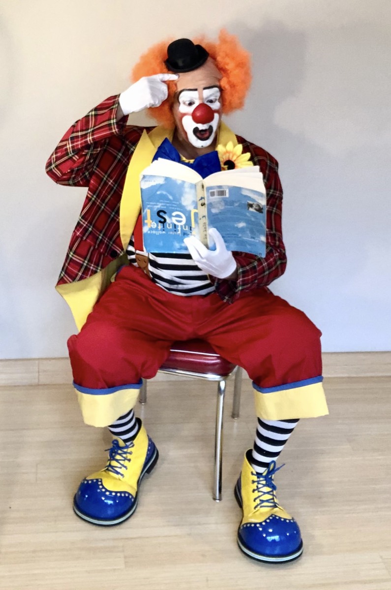 Клоун читає книжку догори дриґом